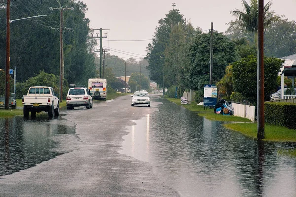 雨后一辆经过被水淹没的沥青路面的汽车的特写镜头 — 图库照片