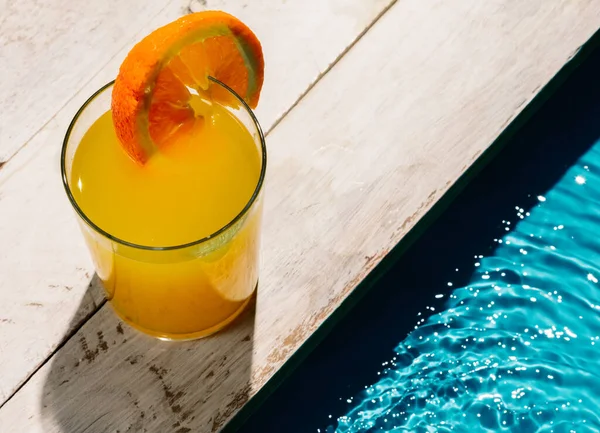 Στιγμιότυπο Μιας Κούπας Χυμό Πορτοκαλιού Φέτα Πορτοκαλιού Δίπλα Στην Πισίνα — Φωτογραφία Αρχείου