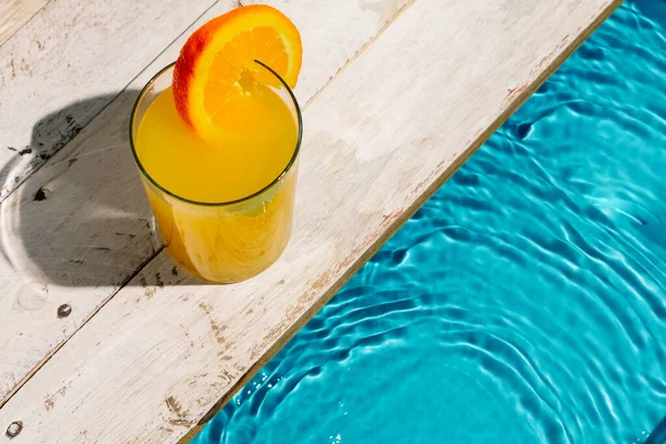 Στιγμιότυπο Μιας Κούπας Χυμό Πορτοκαλιού Φέτα Πορτοκαλιού Δίπλα Στην Πισίνα — Φωτογραφία Αρχείου