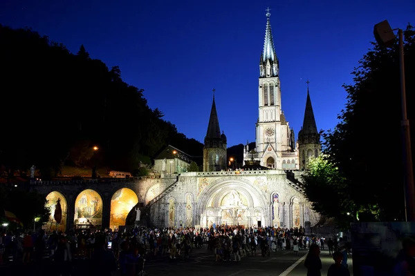 夜になると庭に大勢の人が集まるルルドの美しい大聖堂 — ストック写真