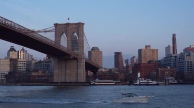 East River üzerindeki Brooklyn Köprüsü New York 'tan gün batımında Aşağı Manhattan' ın rıhtımından izlendi