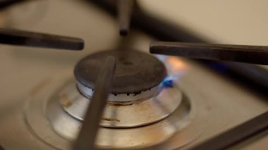 Yanan mavi alevleri olan bir gaz ocağının yakın çekimi.