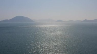 Parıldayan su yüzeyinin, tepelerin arka planındaki güzel hava aracı görüntüleri..