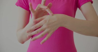 Pembe tişörtlü bir kadının elinde makyaj sıvısı olan bir temel oluşturması.