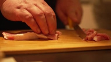 Şef tavuk göğsünü keser.