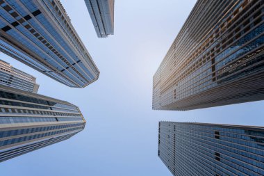 Mavi gökyüzünün altındaki yüksek modern binaların alçak açılı görüntüsü