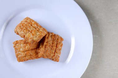Beyaz bir tabakta geleneksel Endonezya usulü kızarmış tempo garit 'in yakın plan fotoğrafı.