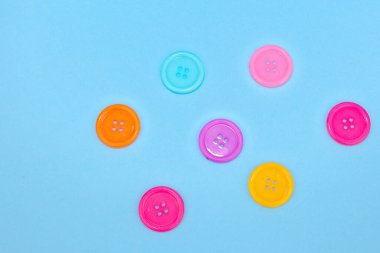 Mavi arkaplanda izole edilmiş renkli düğmelerin yakın plan görüntüsü