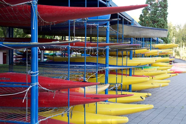 A red and yellow rental kayaks stacked on top of each other