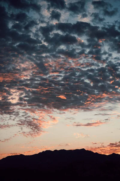 Vertikální Záběr Zataženého Západu Slunce Silueta Pohoří — Stock fotografie