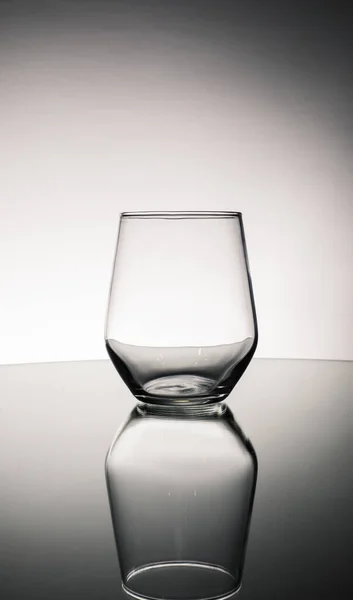 テーブルの上に反射して空のガラスの灰色のショット — ストック写真