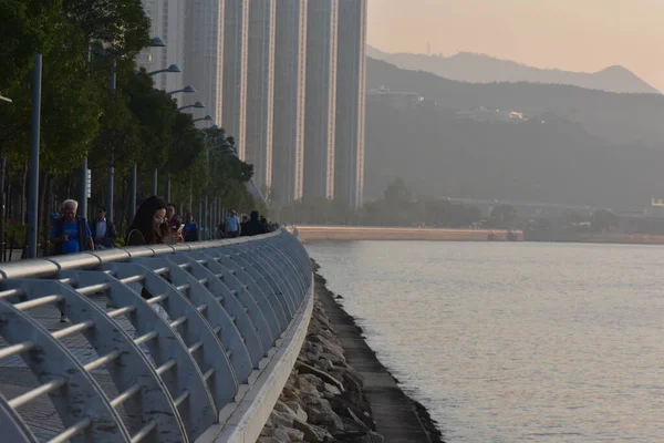 香港の夕日の堤防沿いを歩く人々 — ストック写真