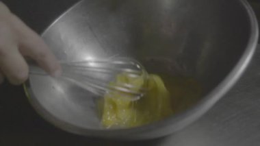 Bir fırıncı kasede yumurta çırpıyor..