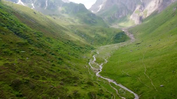 真ん中に小さな水路を持つ美しい緑の山々の空中ショット — ストック動画