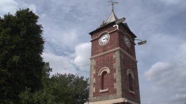 Bulutlu gökyüzüne karşı eski bir saat kulesinin görüntüleri.