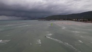 Dalgalı sahilde sörf yapan uçurtmanın HD görüntüsü.