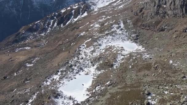 雪の薄い層に覆われた美しい岩の山々の空中ショット — ストック動画