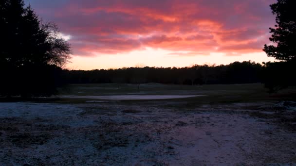 影片展示了一个高尔夫球场在冬季 有一点雪和美丽的日落背景 — 图库视频影像