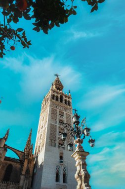 İspanya, Seville 'de mavi gökyüzünde Giralda' nın dikey alçak açılı görüntüsü.