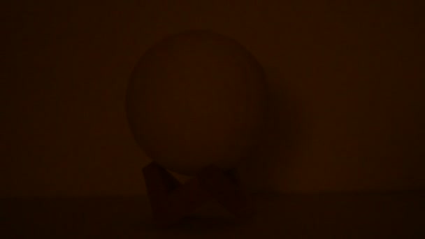 月亮灯由黑色背景的一只手关掉 月亮的球灯 月亮形状的夜光在黑暗中闪耀 — 图库视频影像