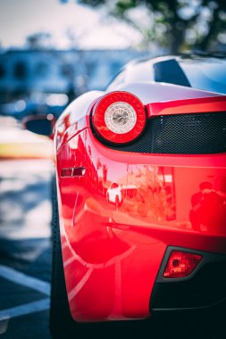 Kırmızı Ferrari 'nin arka lambasının dikey yakın çekimi.