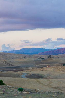 Tepelerin ve bulutlu gökyüzünün dikey görüntüsü. Kırsal alan.