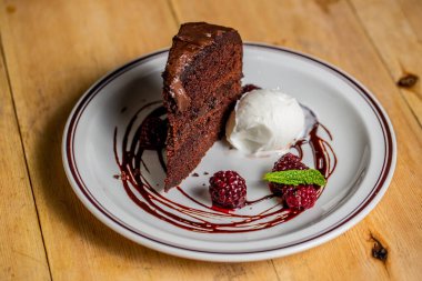 Vanilyalı dondurma ve böğürtlenli çikolatalı kekin yakın çekimi.