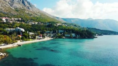 Hırvatistan 'ın kıyı şeridinde güzel tropikal deniz ve mesleki evlere sahip Mlini kıyı köyünün bir klibi