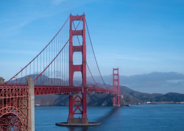 Golden Gate Köprüsü ve arkasında dağlar olan körfez.