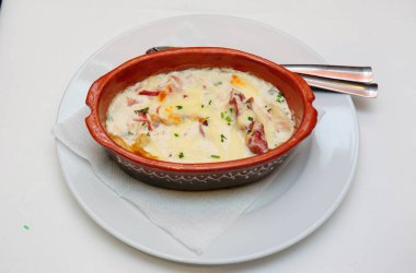 Beyaz tabaktaki kasede bulunan lezzetli Fransız soğan çorbasının yakın plan çekimi.