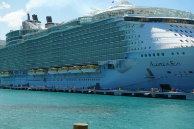Güneşli bir günde limandaki Allure of Sea yolcu gemisinin düşük açılı görüntüsü.