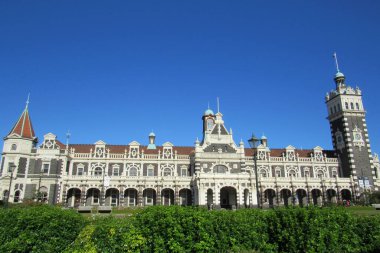 Yeni Zelanda 'daki Dunedin Tren İstasyonu' na karşı yeşil çalıların alçak açılı görüntüsü.