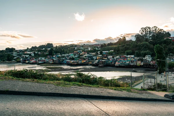 チリの日没時の湖に対するカラフルな家や緑の景色 — ストック写真