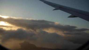 Gün batımı arka planında gökyüzünde uçan bir uçak görüntüsü