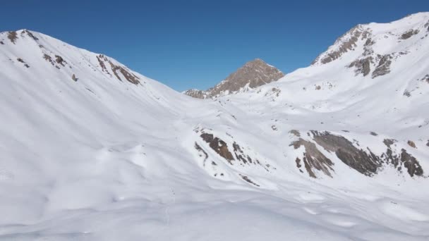 明るい日差しの中で白く輝く雪に覆われた山々の景色 — ストック動画