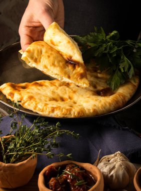 Siyah bir tabakta güzel bir Khachapuri fotoğrafı.