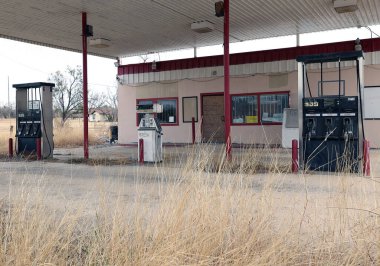 Küçük Lytle kasabasında terk edilmiş eski bir benzin istasyonu. Üzerinde otlar ve eski pompalar var. Teksas, ABD