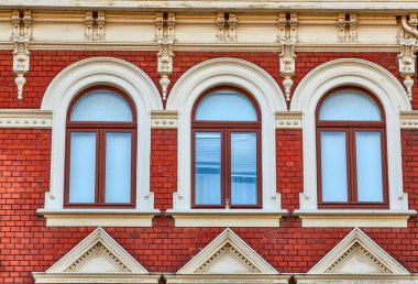 Kemerli pencereli kırmızı tuğla bina cephesi