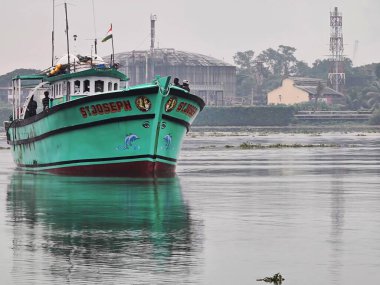 Hindistan, Kochi Ernakulam 'ın deniz suyunda gün batımı gökyüzüne sahip bir balıkçı teknesinin güzel yeşil bir görüntüsü.
