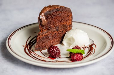 Vanilyalı dondurma ve böğürtlenli çikolatalı kekin yakın çekimi.