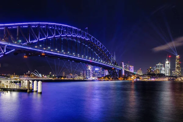 オーストラリア ニューサウスウェールズ州シドニーの紫色のライトアップされたハーバーブリッジの夜景 — ストック写真