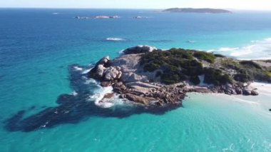 Küçük taştan bir pelerinin havadan görünüşü mavi gökyüzündeki bir sahile bağlıydı.