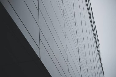 Gri, modern çelik bina cephesinin düşük açılı yakın çekimi.