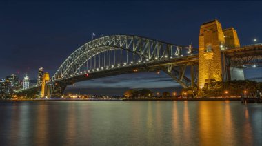 Sydney Limanı Köprüsü 'nün panoramik görüntüsü gece aydınlandı.