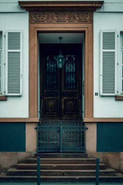 Eski ahşap kapılı bir binanın süslemeli girişinin dikey görüntüsü.