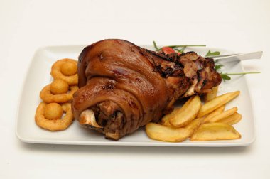 Patates kızartması ve soğan halkasıyla servis edilen lezzetli, pişmiş tavuğun yakın plan çekimi.