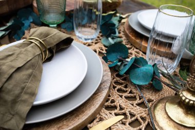 Zarif bir sofra takımı ve ahşap bir masa üzerindeki dekorlar.