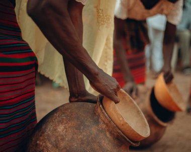 Afrika çömlekçiliğini su dolu tutan kadınların yakın plan fotoğrafı.