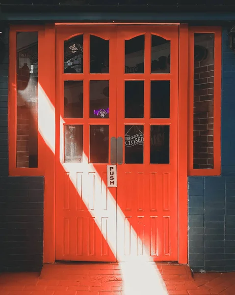 Bgcタグの入り口明るい赤いドア 光のビームがドアの上に落ち道を照らす — ストック写真