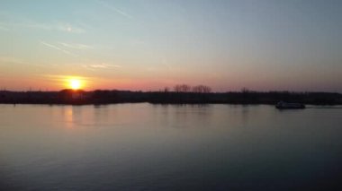 Belçika 'nın Antwerp şehrinin büyük deniz suyu ve siluetli limanının güzel manzarası günbatımı turuncu gökyüzüne karşı.